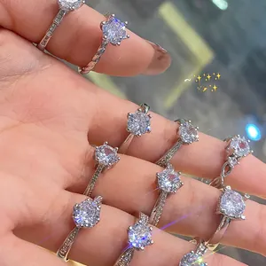 Detail of silver rings with sparkling round diamonds on hand with purple light bokeh