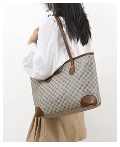 Model wearing a large vintage tote bag with monogram pattern and brown leather trim