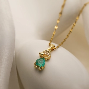 Detailed macro shot of a gold necklace featuring a green heart zircon girl pendant