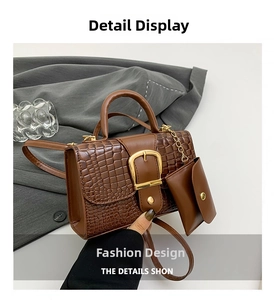 Détail d'un sac à main marron à motif crocodile avec boucle dorée et pochette latérale