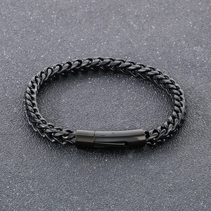 Dettaglio macro di un bracciale a catena intrecciata nera in stile industrial chic