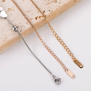 Macro detail of stainless steel extender chains in silver, gold, and rose gold finish