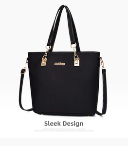 Detail of black pebbled leather tote bag with gold metal logo and adjustable shoulder strap