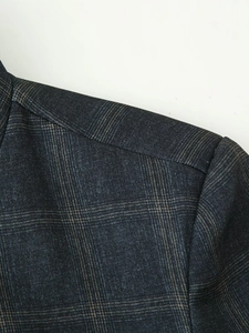 Detail of shoulder seam and plaid pattern on dark grey check blazer jacket fabric