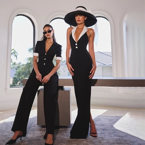 Detail of elegant black deep V-neck jumpsuit and black-and-white halter neck evening dress