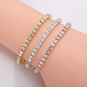 Three rows of gold, silver, and rose gold tennis bracelets with white zircons on a wrist