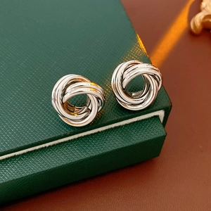 Gros plan de boucles d'oreilles nœud en argent avec design à triple boucle sur boîte