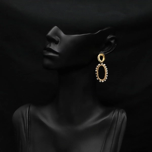 Detailed view of elegant gold oval earrings with small natural pearls on a black mannequin