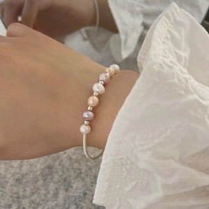 Detail of natural freshwater pearl bracelet with gold-plated accents on a model wrist