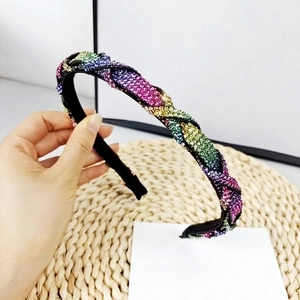 Detalle de una diadema trenzada con pedrería multicolor y cristales brillantes de lujo