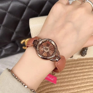 Women's watch with brown flower dial and leather strap, worn by a model in lifestyle setting