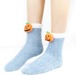Detail von blauen Plüschsocken mit weißem Rand und 3D-Kürbis-Puppen-Applikationen
