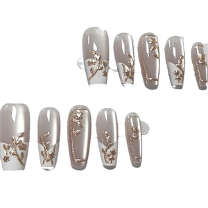 Klassieke witte French Nails met 3D gouden bloemenreliëf op zachtroze basis