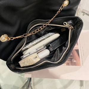 Quilted V-stitch crossbody bag with gold chain showing interior storage space