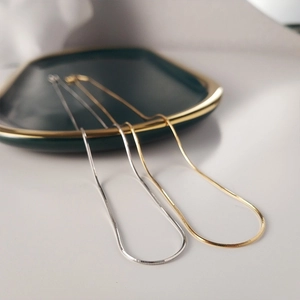 Elegant gold and silver titanium steel snake chain necklaces on a green ceramic tray