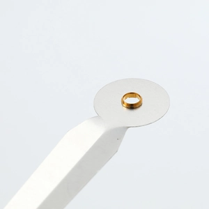 Detailed macro view of golden metal clock movement eyelet held on a precision tool