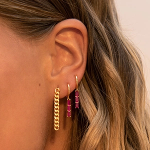Luxury gold drop earrings with pink rectangular zircon and chain on model's ear