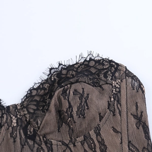 Close-up of black eyelash lace texture with nude lining on a strapless corset top