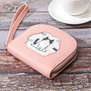 Pink zip wallet with cute cat embroidery and wrist strap on a wooden table setup