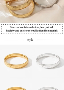 Detail of gold and silver wide bangles featuring star patterns and polished finish