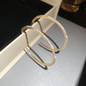 Macro shot of gold hoop earrings with sparkling diamonds in a luxury jewelry box