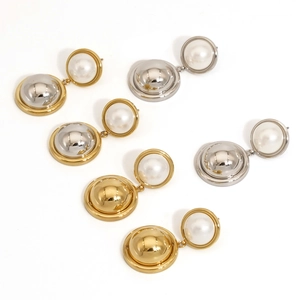 Detailed view of gold and silver tone pearl earrings featuring two-tone metallic spheres