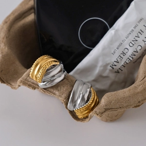 Close-up of dual-tone 18K gold and silver twisted hoop earrings with textured finish