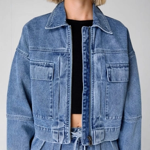 Short blue denim jacket with zipper and cargo pockets in high-waist loose fit for women