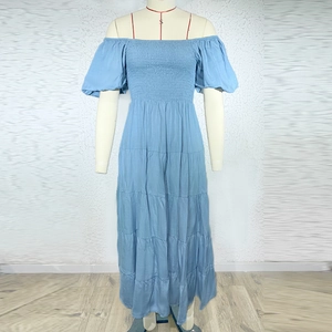 Detail of light blue off-shoulder maxi dress with tiered skirt and smocked elastic bodice