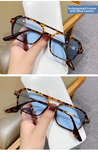 Detailed view of tortoiseshell sunglasses with blue lenses and a white leather case