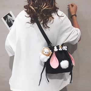 Black canvas bucket bag with pink rabbit ears and cute plush charm on shoulder
