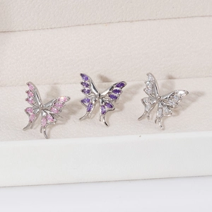 Detailed view of three butterfly ear clips with pink, purple, and white zircon stones