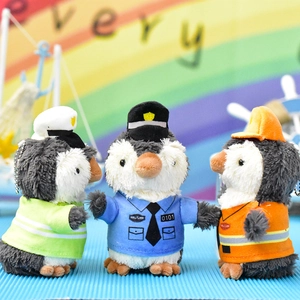 Detailansicht von drei niedlichen Pinguin-Plüschanhängern in verschiedenen Uniformen