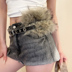 Détail d'une ceinture à paillettes avec œillets argentés et fausse fourrure sur un short