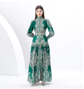 Detail of emerald green maxi dress with retro high collar and baroque floral pattern