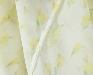 Dettaglio del tessuto in chiffon con stampa floreale gialla e cuciture di alta qualità