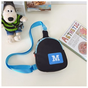 Détail du sac de poitrine en nylon pour enfants, noir et bleu, avec sangle réglable