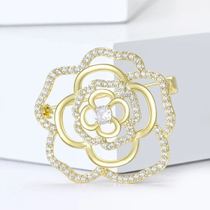 Luxury gold hollow rose brooch with micro-set zircons on white geometric pedestal