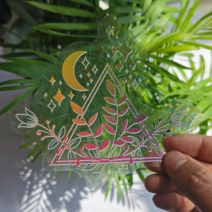 Detail of holographic suncatcher sticker with moon and stars prism pattern