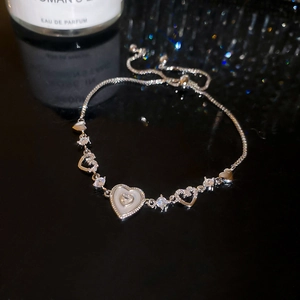 Macro shot of adjustable silver heart bracelet with sparkling zircon and shell inlay