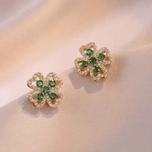 Boucles d'oreilles trèfle dorées avec zircons blancs et pierres précieuses vert émeraude