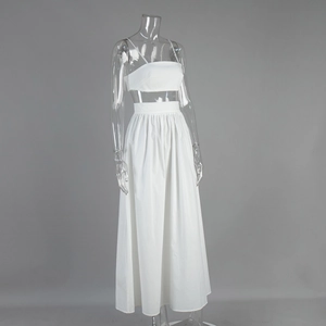 Détail d'un ensemble blanc deux pièces avec crop top à fines bretelles et jupe maxi évasée