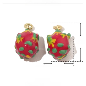 Macro detail of red dragon fruit enamel pendant charms made of copper with gold loops
