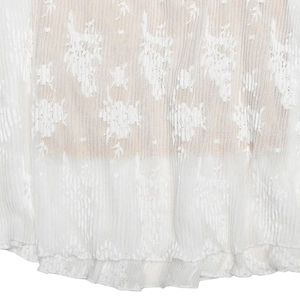 Vue macro du tissu en dentelle blanche montrant la texture et la transparence
