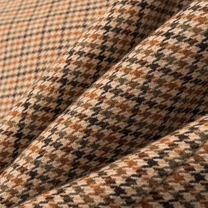 Close-up of premium wool blend houndstooth fabric in brown, khaki, and black texture