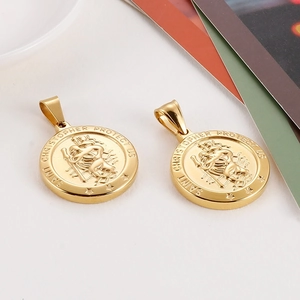 Detail of gold-plated Saint Christopher medal with relief carving and protective text