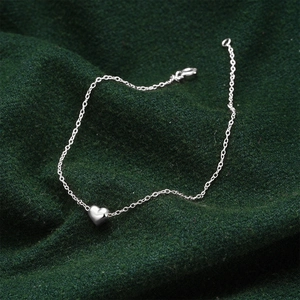 Detailed view of a silver heart pendant on a minimalist S925 sterling silver chain bracelet
