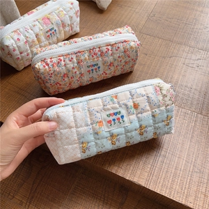 Quilted floral pouch details showing a soft cotton texture with a zipper and BEST fabric label