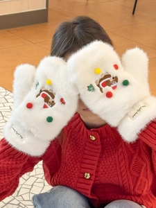 Détail de la texture peluche des moufles blanches avec ourson de Noël et pompons colorés