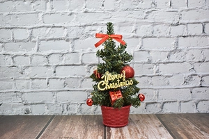 Close-up of a 20cm mini Christmas tree with red bows and a golden Merry Christmas sign